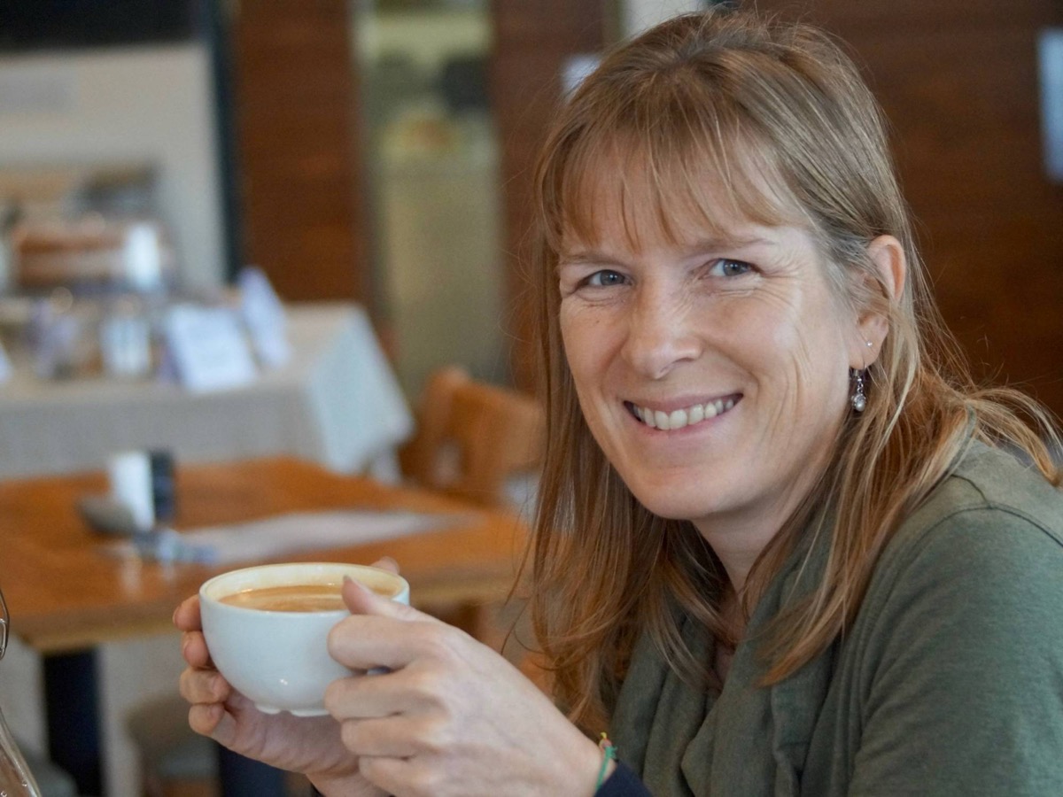 A customer at her table with a morning coffee at Herdwicks